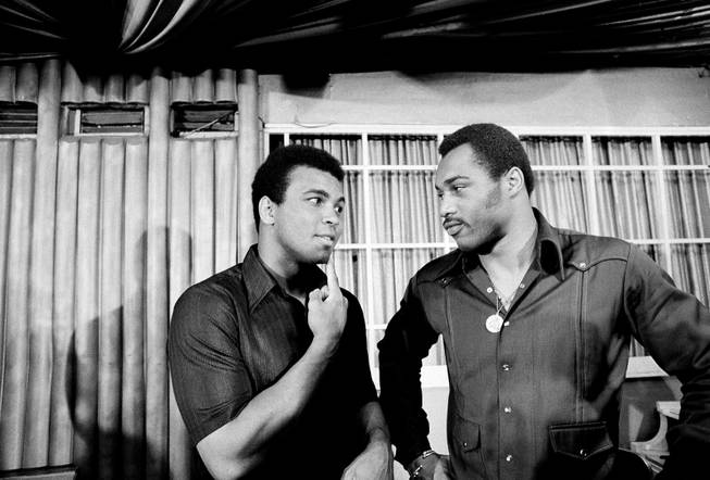 Former world heavyweight champion Muhammad Ali points to where Ken Norton, right, broke his jaw in their March 31 bout, during a news conference in New York, May 3, 1973. Although Ali said his upset loss to Norton was "a humbling experience," he predicted about his next bout with Norton: "I'll win easy."