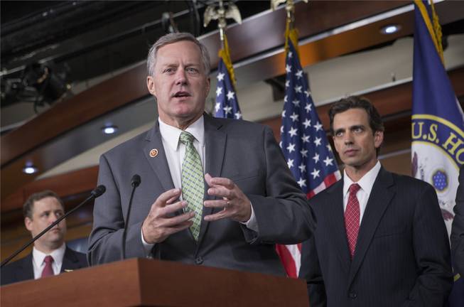 Rep. Mark Meadows, R-N.C, center, Rep. Tom Graves, R-Ga., right, and other conservative Republicans discuss their goal of obstructing the Affordable Care Act, popularly known as Obamacare, as part of a strategy to pass legislation to fund the government, on Capitol Hill in Washington, Thursday, Sept. 19, 2013.