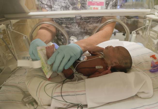 A neonatal intensive care unit nurse puts a foot warmer on Daician Derrico at Summerlin Hospital Medical Center, Friday, Sept. 20, 2013, in Las Vegas. Daician was one in a set of quintuplets born to Deon and Evonne Derrico two weeks ago in Phoenix where the family moved 22 weeks into Evonne Derrico's pregnancy to be closer to doctors specializing in multiple births.