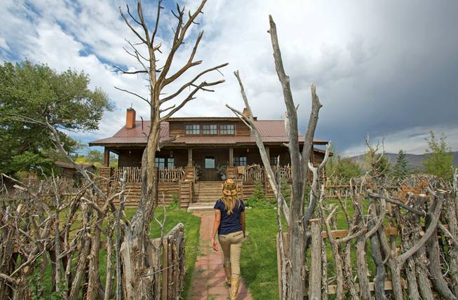 This July 26, 2013, photo shows a woman walking to the gift shop at the Mustang Monument Wild Horse Eco Resortat in Wells, Nev. The resort has a herd of about 700 free-roaming horses, and aims to be an engine for the nonprofit organization Saving America's Mustangs.