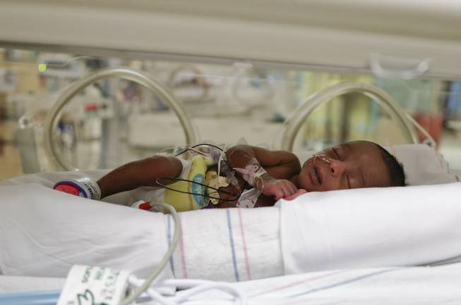 Deniko Derrico sleeps in an incubator at the neonatal intensive care unit at Summerlin Hospital Medical Center, Friday, Sept. 20, 2013, in Las Vegas. Deniko was one in a set of quintuplets born to Deon and Evonne Derrico two weeks ago in Phoenix where the family moved 22 weeks into Evonne Derrico's pregnancy to be closer to doctors specializing in multiple births. They returned to Las Vegas with the quintuplets on three different medical flights on Friday.