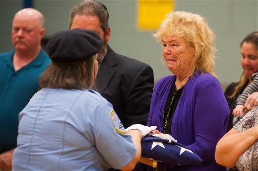 Peggy Eddington-Smith, 69, of Dayton, Nev., receives a flag in honor of her father, Pfc. John Eddington of Leadwood, Mo., in Dayton, Nev., on Saturday, Sept. 21, 2013. Eddington died in World War II three weeks after her birth. Eddington's personal items were discovered by Donna Gregory of St. Louis, who traveled across the country to hand deliver the them to Eddington-Smith.