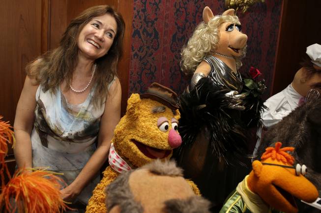 Cheryl Henson, daughter of Jim Henson, left, is surrounded by "muppets" after donating additional Jim Henson objects to the Smithsonian's National Museum of American History, including, from left, Fozzie Bear, Miss Piggy, and Scooter, from The Muppet Show, during a ceremony at the Smithsonian's National Museum of American History in Washington, Tuesday, Sept. 24, 2013.
