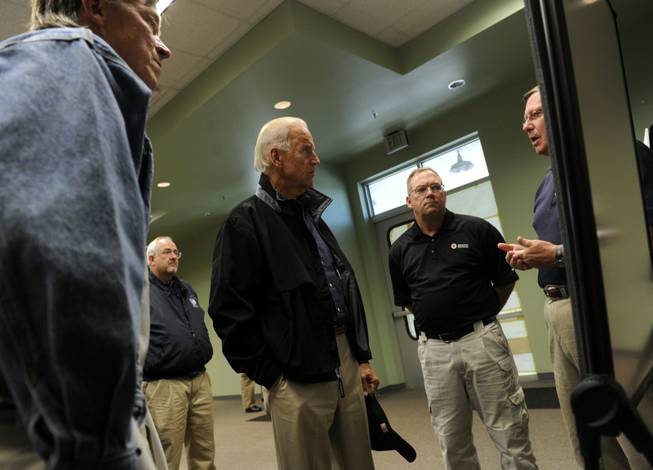 After flying in a helicopter over areas ravaged by the recent flooding, Vice President Joe Biden, center, listens as Supervisor for Weld County Dan Griffiths, right, describes some of the affected areas, Monday, Sept. 23, 2013, in Greeley, Colo. Gov. John Hickenlooper listens at left.