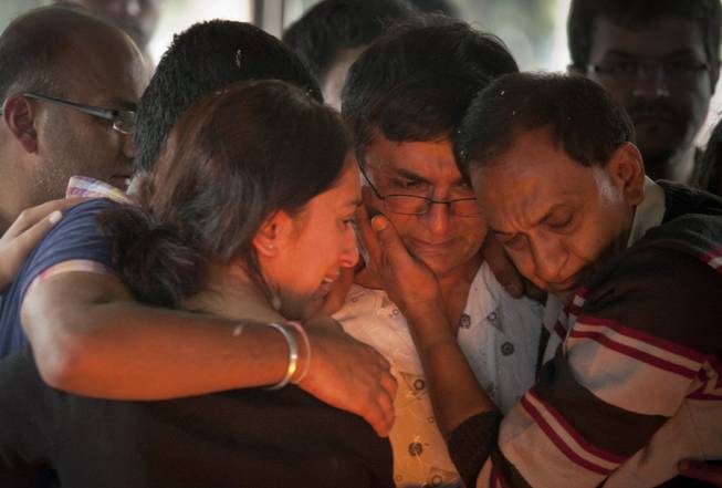 Ramesh Vaya, center, is comforted by family members after lighting the funeral pyre for his wife Malti, who was shot dead in the attack on the Westgate Mall, at her funeral at the Hindu Crematorium in Nairobi, Kenya Tuesday, Sept. 24, 2013. Ramesh and his brother both lost their wives in the attack.