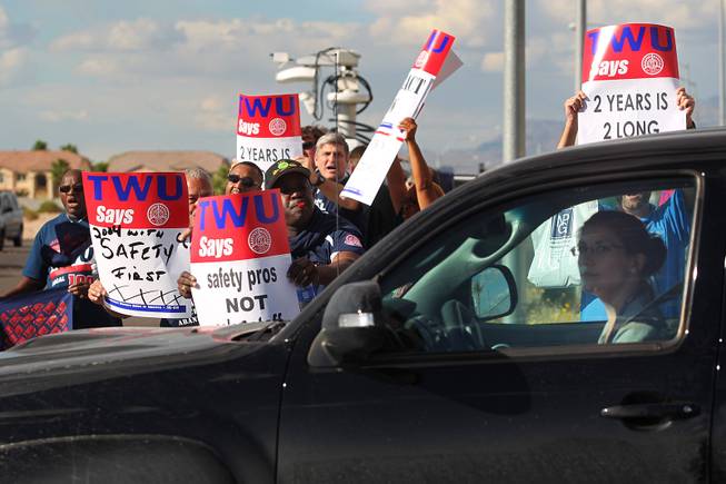 Some of the over 300 members of the Transit Workers Union picketing outside of Allegiant Air headquarters try to get the attention of a woman leaving the airline's parking lot Thursday, Sept. 26, 2013. The union members were trying to raise awareness of Allegiant's customer service record as well as their inability to reach a labor agreement with more than 600 of their flight attendants.