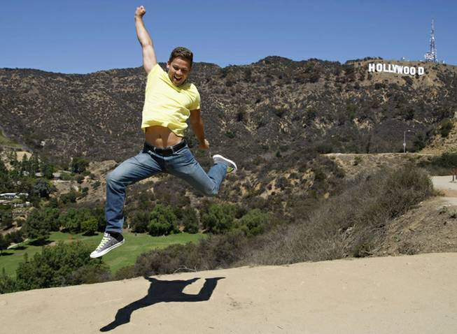 Waldemar Scott, of Stuttgart, Germany, jumps in front of the Hollywood sign as he has his picture taken by a friend Sept. 26, 2013, near Canyon Lake Drive in the Hollywood Hills area of Los Angeles. Residents in the Beachwood Canyon area of Los Angeles are fighting with the Hollywoodland Homeowners Association over tourists looking at the Hollywood sign.