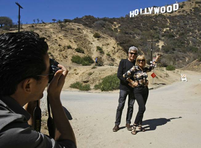 Silvestre Llobet and his wife Elena Domenech are photographed by their son, Alejandro Llobet (left) under the Hollywood sign on Sept. 26, 2013, in the Beachwood Canyon area of Los Angeles. Silvestre and Elena are visiting from Barcelona, Spain. Residents in the Beachwood Canyon area of Los Angeles are fighting with the Hollywoodland Homeowners Association over tourists looking at the Hollywood sign.