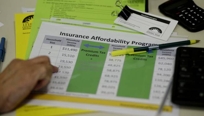 A volunteer counselor with Insure Central Texas uses a chart to help explain health insurance options, Tuesday, Oct. 1, 2013, in Austin, Texas. Texas hospitals, clinics and charities are gearing up to help uninsured Texans enroll in health care exchanges after Gov. Rick Perry declared the state government would do as little as possible to help implement the Affordable Care Act.