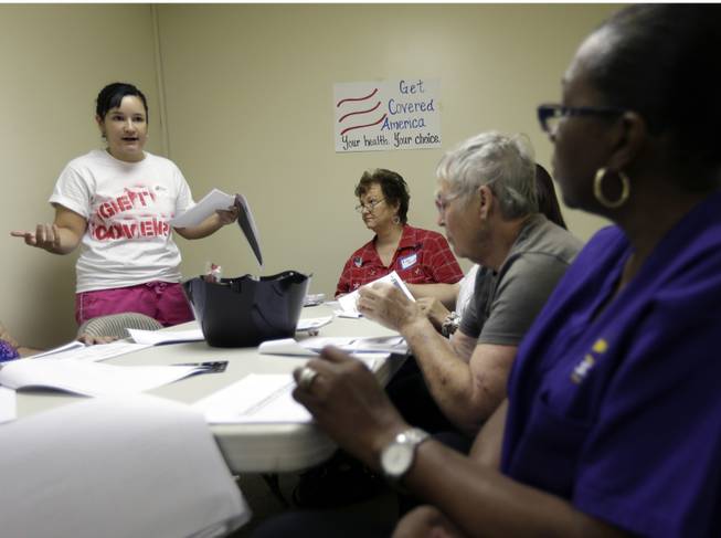 Alex Gonzalez, left, a volunteer with Enroll America, a private, non-profit organization running a grassroots campaign to encourage people to sign up for health care offered by the Affordable Care Act, trains volunteers who work the phones to inform residents of their health care options, Tuesday, Oct. 1, 2013, in Tampa, Fla. After months of build-up, Florida residents can start shopping for health insurance on government-run online marketplaces as the key component of the Affordable Care Act goes live. (AP Photo/Chris O'Meara)
