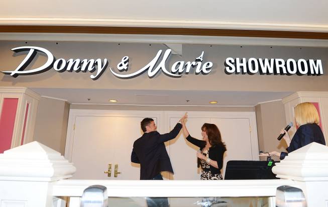 Flamingo Las Vegas Regional President Eileen Moore, right, Donny Osmond and Marie Osmond unveil the signage for the newly renamed Donny & Marie Showroom at Flamingo Las Vegas on Wednesday, Oct. 2, 2013.