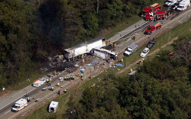 In this aerial photo, emergency workers respond to a crash involving a church bus and a tractor-trailer near Dandridge, Tenn., on Wednesday, Oct. 2, 2013. Authorities say a tire on the bus blew out and the bus hit the tractor-trailer and a sport utility vehicle, killing eight people.