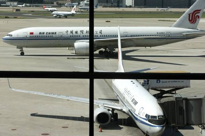 An Air China's Boeing 777 jet, center, taxi to a gate after landing at Beijing International Airport in Beijing, China, Thursday, Sept. 5, 2013. Boeing Co. says it expects Chinas airlines to triple the size of their fleets over the next two decades, driven by strong economic growth and rising tourism spending.