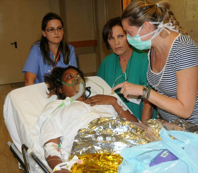A woman receives assistance at the Palermo Civico hospital, Italy, Thursday, Oct. 3, 2013 after being rescued off the Italian island of Lampedusa. A ship carrying African migrants to Europe caught fire and capsized Thursday off the southern Italian island of Lampedusa, killing at least 94 people as hundreds were dumped into the sea, officials said.