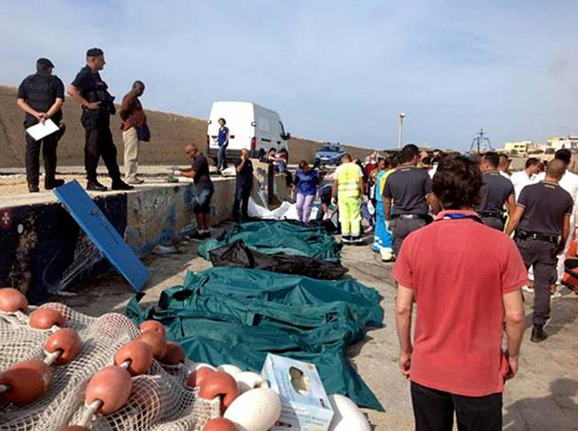 Bodies of drowned migrants are lined up in the port of Lampedusa Thursday, Oct. 3, 2013. A ship carrying African migrants to Europe caught fire and capsized off the Italian island of Lampedusa on Thursday, killing at least 94 people as it spilled hundreds of passengers into the sea, officials said.