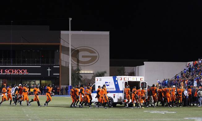 Booker T. Washington High of Miami players rush over to teammate Aquil Knowles to wish him well before he is transported off the field in an ambulance after injuring his leg during their game against Bishop Gorman Friday, Oct. 4, 2013 at Bishop Gorman. The No. 1 ranked Washington won the game 28-12.