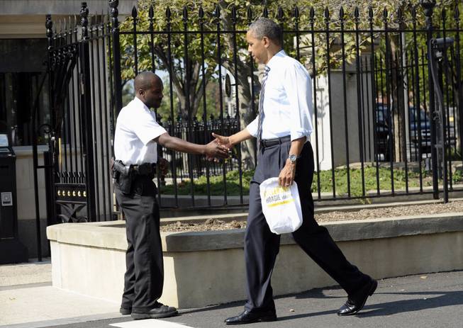 President Barack Obama shakes hands with a uniformed member of the Secret Service outside the White House in Washington, Friday, Oct. 4, 2013, as he returned to the White House after leaving to get lunch nearby. The president and Vice President Joe Biden stepped out of the White House on a surprise and rare off-campus stroll to grab lunch at a neighborhood eatery.