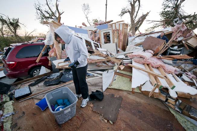 Traci Krus looks at a pictures of her family that she found in her damaged home Saturday, Oct. 5, 2013, in Wayne, Neb. A tornado struck the northeast Nebraska town Friday, causing millions of dollars in damage, but the mayor says no one was killed and the injuries reported have been minor. Mayor Ken Chamberlain said that officials have accounted for all residents in town.