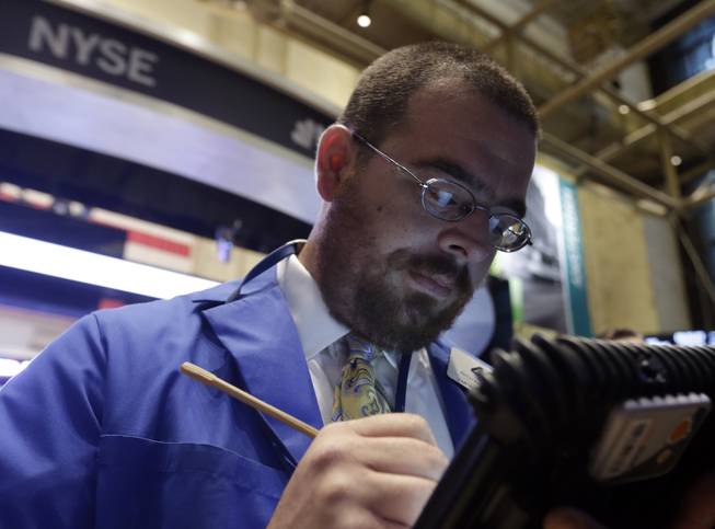 In this Wednesday, Oct. 2, 2013, file photo, trader Richard Scardino works on the floor of the New York Stock Exchange. Stock futures were falling sharply, Monday, Oct. 7, 2013, as the U.S. government headed into the second week of a partial shutdown with no signs of a budget agreement in sight.