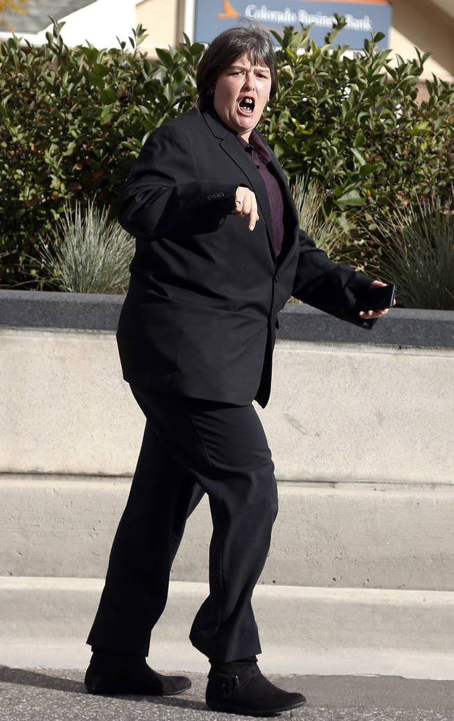Lorinda Bailey shouts at members of the media after walking from the Denver Justice Center on the day of the first hearing in her felony child abuse case, in Denver, Tuesday, Oct. 8 2013. Bailey, 35, who is free on bond, and Wayne Sperling, 66, who is in custody, are charged with child abuse for allegedly starving their four sons, ages 2, 4, 5 and 6, and keeping them in an apartment full of feces and flies.All four have been placed in protective care and have undergone hospital exams that found that they could only communicate in grunts, were malnourished and were not toilet trained, according to an arrest affidavit.