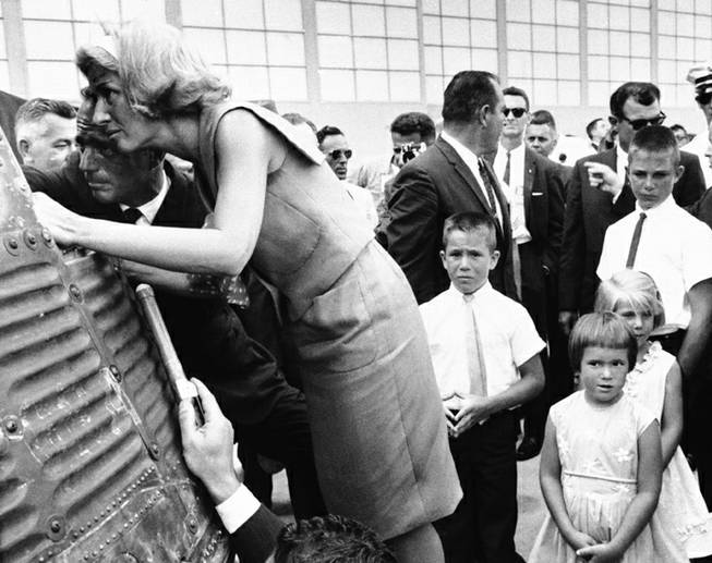 Astronaut Scott Carpenter and his wife, Rene, inspect interior of his space capsule during ceremonies at Cape Canaveral, Florida on May 27, 1962. At left are their children, Robyn Jay, 10; Candace Noxon, 5, foreground Kristine Elaine, 6, and Mark Scott, 12, right center. Carpenter was awarded the National Aeronautics and Space Administration distinguished service medal for his orbital flight.
