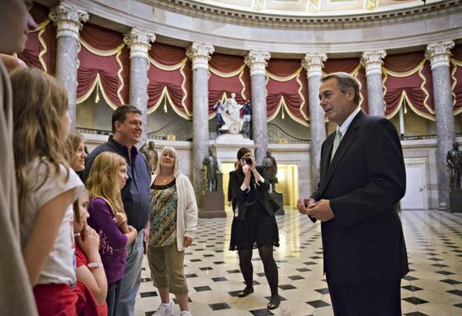 House Speaker John Boehner of Ohio stops to greet visitors from Panama City, Fla., guests of Rep. Steve Southerland, R-Fla., in Statuary Hall on Capitol Hill in Washington, Friday, Oct. 11, 2013. After weeks of ultimatums, President Barack Obama and congressional Republicans are exploring whether they can end a budget standoff that has triggered a partial government shutdown and edged Washington to the verge of a historic, economy-jarring federal default.