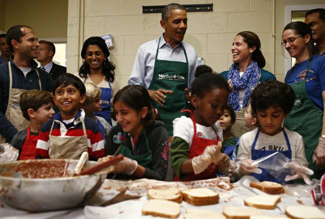 President Barack Obama stops by a table of grade school aged volunteers from Sidwell Friends School making peanut butter and jelly sandwiches as he visits Martha's Table, which assists the poor and where furloughed federal employees are volunteering, in Washington, Monday, Oct. 14, 2013. Speaking there Obama said that if Republicans can't resolve the standoff over the debt ceiling and the partial government shutdown, quote, "we stand a good chance of defaulting."