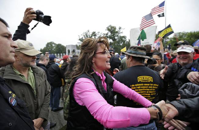 Former Alaska Gov. Sarah Palin, arrives for a rally at the World War II Memorial in Washington Sunday, Oct. 13, 2013, to protest, as she said, how politicians used "your hard-earned tax money to barricade the memorials" during the federal government shutdown. She called it a "slimdown," saying it only halted a small part of the "bloated" government. The Memorial has been closed to the public since the shutdown.
