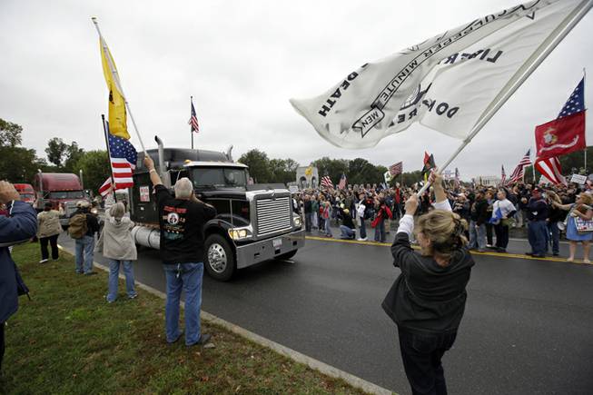 Protesters cheer as large trucks arrive at a rally at the World War II Memorial on the National Mall in Washington Sunday, Oct. 13, 2013. Leaders in the U.S. Senate have taken the helm in the search for a deal to end the partial government shutdown and avert a federal default. The rally was organized to protest the closure of the Memorial, subsequent to the shutdown, and lack of access to it by World War II veterans, who traveled there on Honor Flight visits.