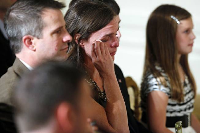 An unidentified audience member wipes her eye as President Barack Obama speaks about the gallantry of former Army Capt. William D. Swenson of Seattle, Wash., during the Medal of Honor ceremony in the East Room at the White House in Washington, Tuesday, Oct. 15, 2013. Swenson was awarded the Medal of Honor for his actions in a lengthy battle against Taliban insurgents in the Ganjgal valley near the Pakistan border on Sept. 8, 2009, which claimed the lives of five Americans, 10 Afghan army troops and an interpreter.