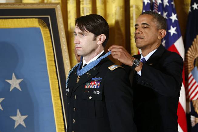 President Barack Obama awards the Medal of Honor to former Army Capt. William D. Swenson of Seattle, Wash., during a ceremony in the East Room at the White House in Washington, Tuesday, Oct. 15, 2013. Swenson was being awarded the Medal of Honor for his actions in a lengthy battle against the Taliban insurgents in the Ganjgal valley near the Pakistan border on Sept. 8, 2009, which claimed the lives of five Americans, 10 Afghan army troops and an interpreter.