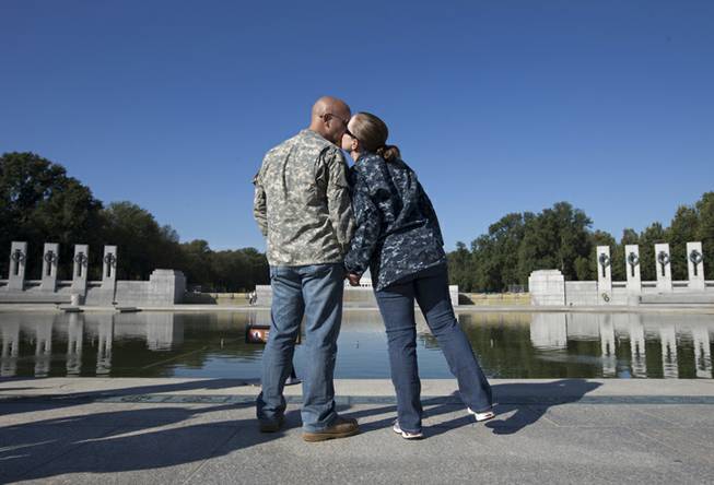 Chris and April Vannoy, of Woodbridge, Va., kiss during a rally at the National World War II Memorial, Tuesday, Oct. 15, 2013, in Washington, held by the Military Coalition, a coalition of 33 of the leading veterans and uniformed services organizations, to demand an end to the partial government shutdown. April is currently serving the the Navy and Chris is going to school full time and served in the Army. The federal government remains partially shut down and faces a first-ever default between Oct. 17 and the end of the month.
