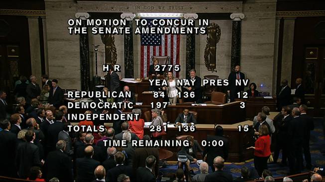 In this image from House Television, with partial voting totals on the screen, a woman, at the rostrum just below the House presiding officer, seen between the "yea" and "nay" wording, is removed from the House chamber after she began shouting during the vote for the bill to end the partial 16-day government shutdown and to fund the government. The woman was described by lawmakers and aides as a long-time House stenographer.