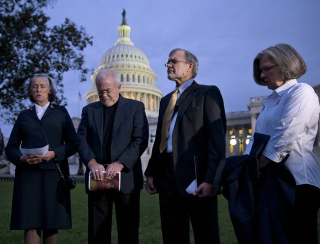 With time growing desperately short for Congress to prevent a threatened Treasury default and stop a partial government shutdown, a group of ministers, the Circle of Protection, pray at dawn at the Capitol to draw attention to lawmakers that political divisiveness hurts the most vulnerable Americans, in Washington, Tuesday, Oct. 15, 2013. From right are Kathy Saile, Gary Cook, Rev. Jim Wallis, and Major Carole Busroe of the Salvation Army.