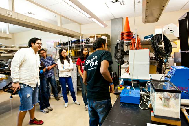 Graduate assistant Dev Raj Sharma, right, activates a visual shake table as fellow students watch a demonstration of furniture falling in a home during a simulated earthquake after the Great Nevada ShakeOut earthquake drill held in the Applied Geophysics Center at UNLV at 10:17 a.m. Thursday morning in Las Vegas, October 17, 2013.