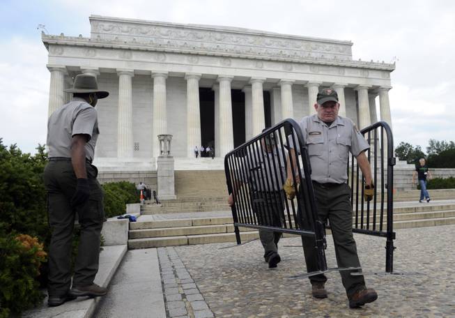 National Park Service employee James Mitchell, right, and others, remove barricades from the grounds of the Lincoln Memorial in Washington, Thursday, Oct. 17, 2013. Barriers went down at National Park Service sites and thousands of furloughed federal workers began returning to work throughout the country Thursday after 16 days off the job because of the partial government shutdown.