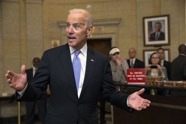 Vice President Joe Biden, left, greets Environmental Protection Agency workers as they return to work after 16 days of a government shutdown at the William Jefferson Clinton Federal Building in Washington on Thursday, Oct. 17, 2013. Thousands of furloughed federal workers returned to work across the country Thursday after 16 days off the job due to the partial government shutdown.