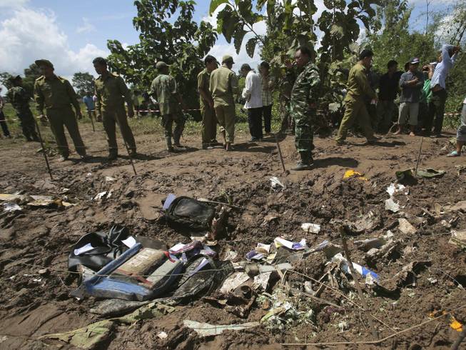 Lao soldiers and policemen work at the scene where a Lao Airlines turboprop plane hit hard before skidding into the Mekong River, in Pakse, Laos on Thursday, Oct. 17, 2013. The aircraft ran into extreme bad weather conditions and crashed Wednesday into the Mekong River, killing all 49 people onboard.