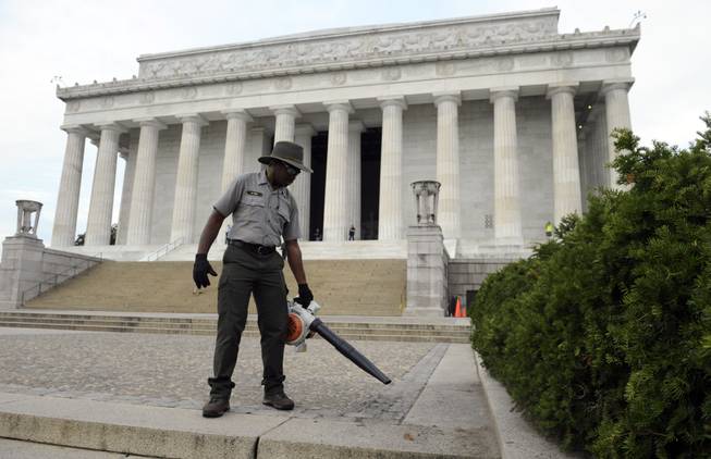 National Park Service employee Paul Fox of Washington, who had been off work for the last 16 days, uses a blower to clean the grounds of the Lincoln Memorial in Washington, Thursday, Oct. 17, 2013. Barriers went down at National Park Service sites and thousands of furloughed federal workers began returning to work throughout the country Thursday after 16 days off the job because of the partial government shutdown.