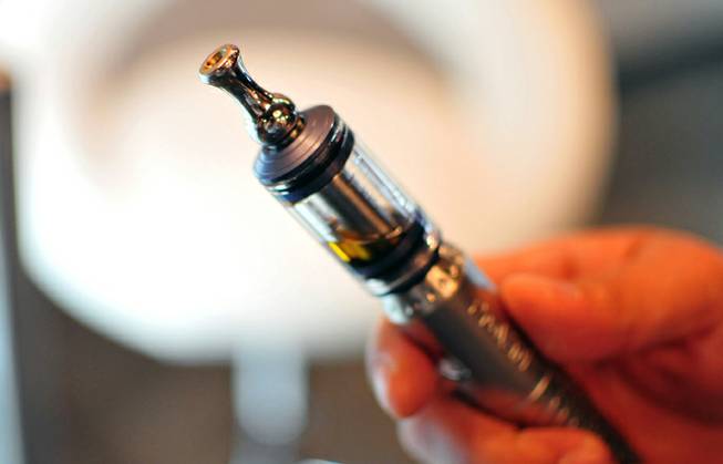 An e-cigarette "mod" pipe with a vial of nicotine is shown on Friday, Oct. 11, 2013, at The Vapery, a local vapor shop located at 8060 S. Rainbow Road. The rise in e-cigarette use among young adults and teenagers is a growing concern among health officials, who have long waged a public health campaign against smoking.