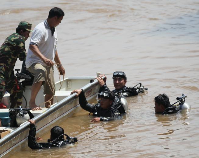 Divers search for bodies of victims of a crashed Lao Airlines plane in the Mekong River in Pakse, Laos, Thursday, Oct. 17, 2013. Rescuers in fishing boats pulled bodies from the muddy Mekong River on Thursday as officials in Laos ruled out finding survivors from a plane that crashed in stormy weather, killing 49 people from 11 countries.