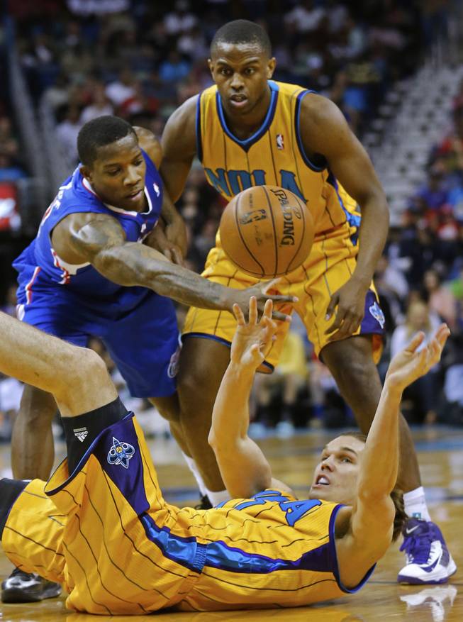 New Orleans Hornets power forward Lou Amundson, bottom, reaches for the ball from the floor as Los Angeles Clippers point guard Eric Bledsoe (12), left, and Hornets small forward Darius Miller (2) react in the first half of an NBA basketball game in in New Orleans, Friday, April 12, 2013.