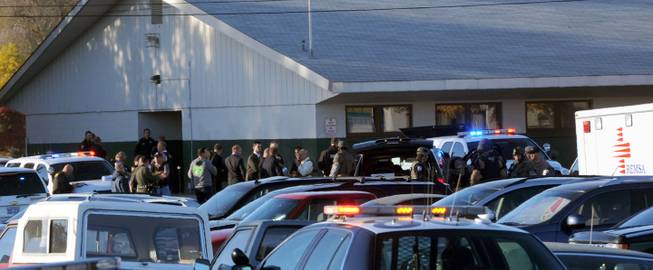 Law enforcement personnel gather at the scene of a shooting at Sparks Middle School in Sparks, Nev. on Monday, Oct. 21, 2013. A student at the school opened fire on campus just before the starting bell Monday, wounding two boys and killing a teacher who was trying to protect other children, Sparks police and the victim's family members said.
