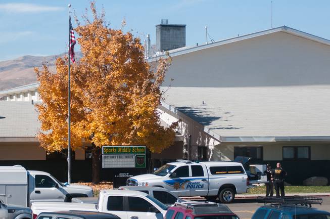 Police are staged in front of Sparks Middle School after a shooting in Sparks, Nev. on Monday, Oct. 21, 2013 in Sparks, Nev. A middle school student opened fire on campus just before the starting bell Monday, wounding two boys and killing a staff member who was trying to protect other children, Sparks police said Monday.