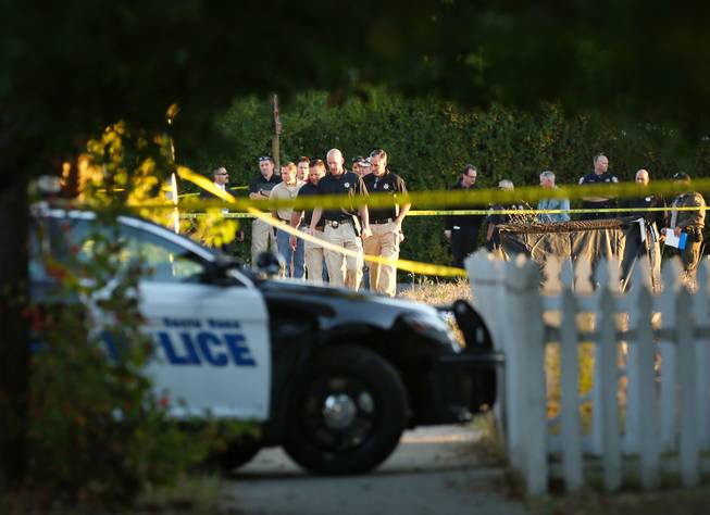 In this photo taken Tuesday Oct. 22, 2013, law enforcement investigators look over the body of a 13-year-old boy shot and killed by officers in Santa Rosa, Calif. Two California sheriff's deputies saw the boy walking with what appeared to be a high-powered weapon Tuesday, sheriff's Lt. Dennis O'Leary said. The replica gun resembled an AK-47, according to a photograph released by the sheriff's office.