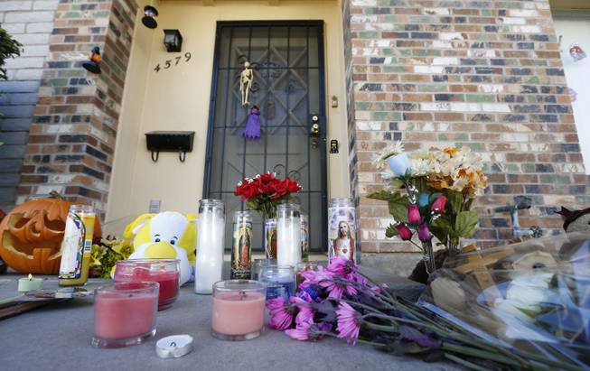 A makeshift memorial has been set up in front of the Moore home on Monday Oct. 28, 2013, in Phoenix, to remember the four shooting victims. Police say loud barking dogs might have led to 56-year-old Michael Guzzo, to kill four of his neighbors and the neighbors' two dogs before turning the gun on himself, and dying.