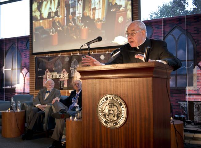 In this photo provided by St. Louis University, the Rev. John Padberg, S.J., director of the Institute of Jesuit Sources, speaks during a panel discussion at St. Louis University in St. Louis, Tuesday, Oct. 29, 2013, about the month-long 1949 demon-purging ritual at the school’s former Alexian Brothers Hospital. The treatment of an unidentified suburban Washington, D.C., boy formed the basis for the 1971 novel by William Peter Blatty, The Exorcist, and the film of the same name two years later. Listening from left to right, are: Thomas B. Allen, author of Possessed: The True Story of an Exorcism, and John Waide, archivist at Saint Louis University.