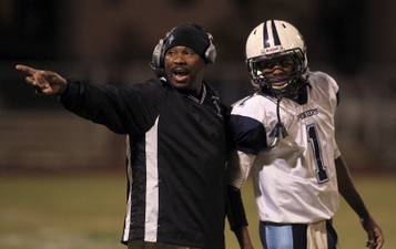 Canyon Springs head coach Hunkie Cooper shouts orders as QB Bradley Alexander (1) lawaits his next play call. Canyon Springs defeated Las Vegas High 21-14 on Friday, Nov. 1, 2013.