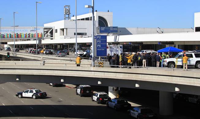 Police, emergency response vehicles and officials are positioned outside Terminal 3 at Los Angeles International Airport on Friday, Nov. 1, 2013. Shots were fired Friday at Los Angeles International Airport, prompting authorities to evacuate a terminal and stop flights headed for the city from taking off from other airports.