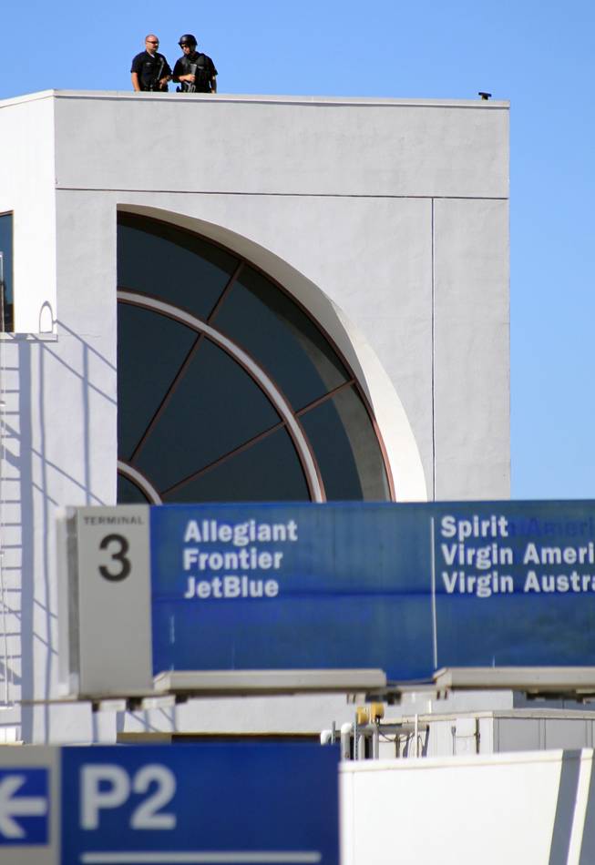 Police officers stand guard atop Terminal 3 at the Los Angeles International Airport on Friday Nov. 1, 2013. Shots were fired Friday at Los Angeles International Airport, prompting authorities to evacuate a terminal and stop flights headed for the city from taking off from other airports.